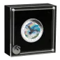 Preview: 1 Unze Silbermünze Australien 2026 „Australian Silver Swan“ der Perth Mint in farbiger Ausführung. Das Motiv zeigt einen schwarzen Schwan im Flug über einem See und einer Landschaft mit Regenbogen und Wolken.