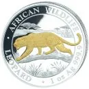 1 Unze Silbermünze Somalia 2026 aus der Serie African Wildlife mit dem Motiv eines Leoparden auf einem Baumstamm. Teile des Leopardenmotivs und der Münzgestaltung sind vergoldet. Im Hintergrund ist eine afrikanische Landschaft dargestellt. Auf der Münze s